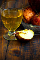 glass of wine on a wooden table with a fresh apples