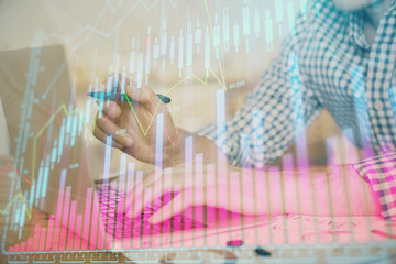 Multi exposure of forex graph with man working on computer on background. Concept of market...
