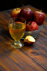 glass of wine and apple on wooden background