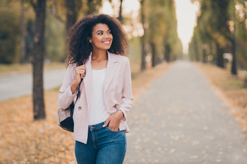 Photo of amazing pretty dark skin curly lady smiling handsome guy walking park after college lectures hold backpack warm autumn season wear jacket jeans outdoors - Powered by Adobe