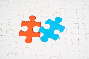 Blue jigsaw piece and red hold jigsaw