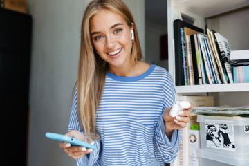 Young cute girl at home using mobile phone