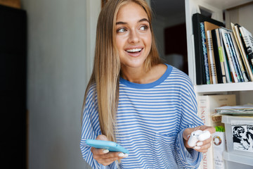 Young cute girl at home using mobile phone