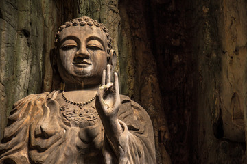 Fototapeta na wymiar A Buddha with the peace symbol inside the Marble Mountains of Da Nang