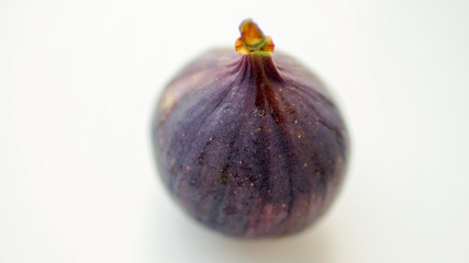 Ripe sweet fig on white blurred table.