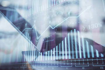 Forex graph hologram on table with computer background. Double exposure. Concept of financial...