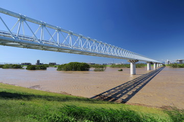 増水した台風一過の翌朝の江戸川とガス導管専用橋風景