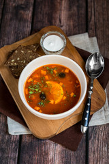 Caesar salad with grilled chicken with dressing on rustic wooden table