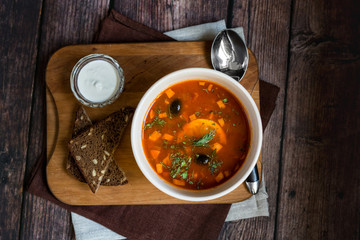 Caesar salad with grilled chicken with dressing on rustic wooden table