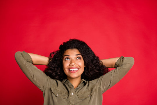 Photo of curly wavy cheerful positive nice pretty cute youngster looking up in search of interesing information holding head with hands isolated vivid color background