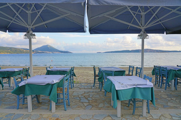 Table set on the beach at a traditional Greek taverna in Gialova on the Navarino Bay in Messinia in the Peloponnese region of Greece near Pylos