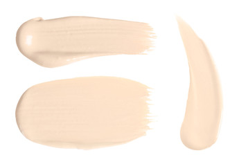 Set with samples of liquid foundation on white background, top view
