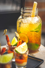 Classic cuban mojito with lime, mint and black sugar served in a big glass and prawn skewer tapas
