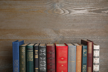 Stack of hardcover books on wooden background. Space for text