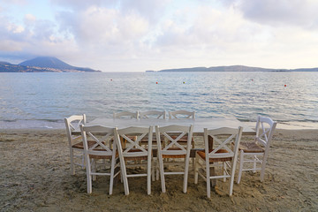 Fototapeta na wymiar Table set on the beach at a traditional Greek taverna in Gialova on the Navarino Bay in Messinia in the Peloponnese region of Greece near Pylos