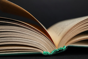 Closeup view of open book on black background