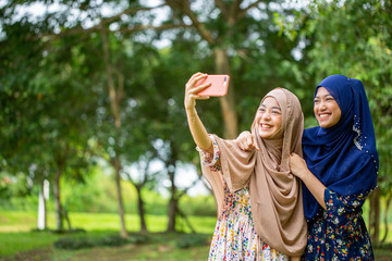 Two Asian woman musalim selfie in the garden.