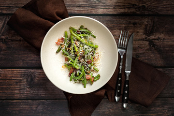 Green beans with bacon and cheese on dark wooden table