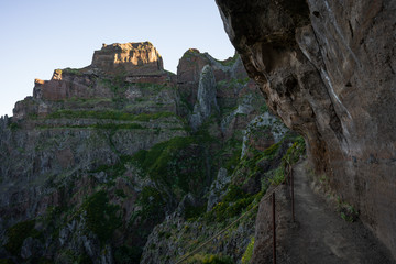 The path snuggles close to the overhanging rock walls
