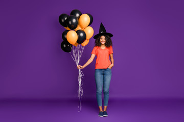 Full length body size photo of cheerful positive cute nice pretty sweet girlfriend wearing jeans denim like a witch holding air balls isolated vivid violet color background