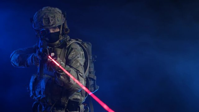 a man in a military uniform with a weapon in his hands and a laser sight