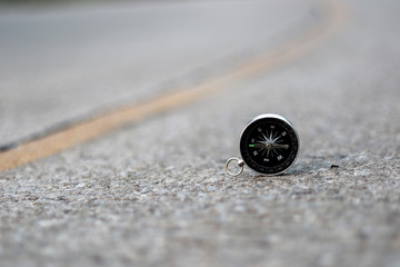 A compass on road texture background, journey of life concept