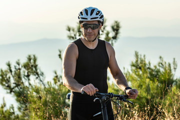 Male cyclist standing with his bike