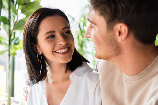 selective focus of happy woman looking at man