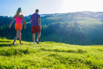 Running fitness couple of runners doing sport on road outdoor. Active living man and woman jogging training cardio in summer outdoors nature.