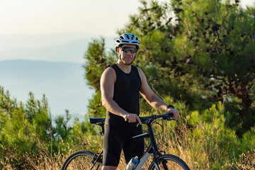 Obraz premium Male cyclist standing with his bike