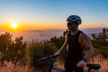 Male biker watching the sunset