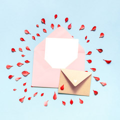 Envelope of pink color inside which is a blank white sheet of paper, the background is blue. Red leaves. Place for your design.