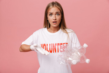 Image of outraged woman volunteer in uniform holding plastic bottles