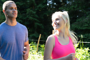 Obraz premium Running fitness couple of runners doing sport on road outdoor. Active living man and woman jogging training cardio in summer outdoors nature.