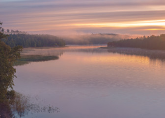 Long Exposure of Sunset at the Paijanne lake. Beautiful scape with sunrise sky, pine forest and water. Lake Paijanne, Finland.
