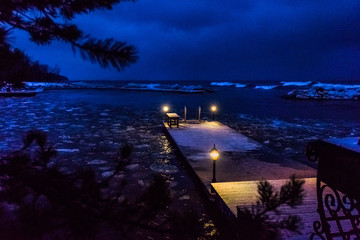 winter evening seascape with a pier, cold lights, right