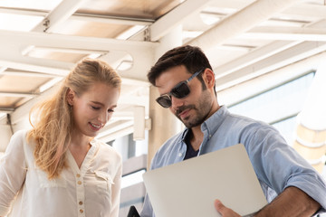 Businessman Showing Laptop To Female Colleagues In City