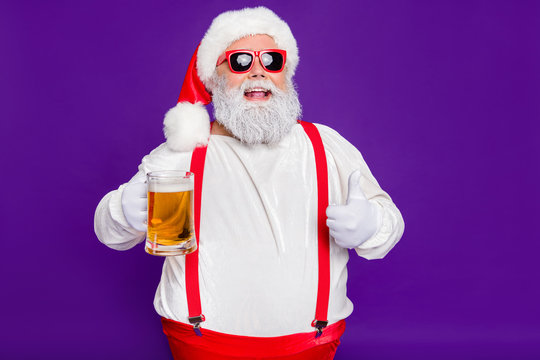 Close-up portrait of his he nice cheery glad cheerful satosfied bearded thick fat Santa drinking beer showing thumbup isolated over bright vivid shine vibrant violet lilac background
