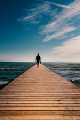 Mann Silhouette Laufend auf einem Steg Meer  - obrazy, fototapety, plakaty