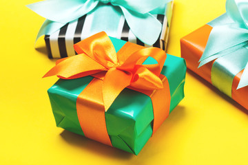 Set of attractive gifts on the yellow background. Trendy orange and green colors. Merry Christmas, St. Valentine's Day, Happy Birthday and other holidays concept