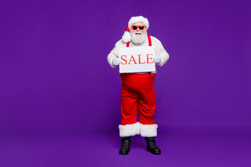Fototapeta na wymiar Full length body size view of his he nice confident cheerful cheery bearded thick fat Santa holding in hands demonstrating sale placard isolated on bright vivid shine vibrant violet lilac background