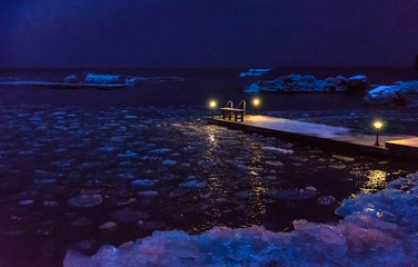 landscape with night Bay with lights on a pier and reflection 