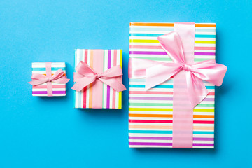 wrapped Christmas or other holiday handmade present in paper with pink ribbon on blue background....