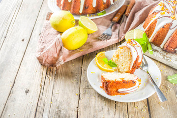 Homemade lemon bundt cake with sugar icing, fresh lemons and mint leaves, copy space