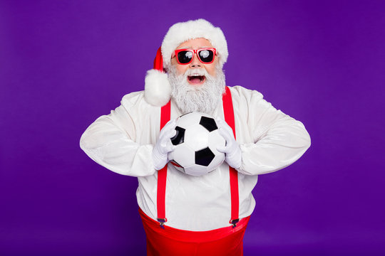 Photo of grey haired santa father holding football ball spend newyear night watching champion league excited final game wear sun specs costume isolated purple background