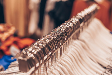 A lot of clothes hangers on the rack in the shop. Concept of shopping and fashion. © bulgn