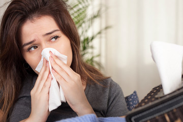 young woman got flu and sitting on sofa