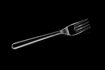 Transparent plastic fork isolated on black background