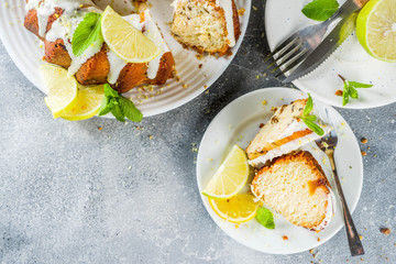 Homemade lemon bundt cake with sugar icing, fresh lemons and mint leaves, copy space