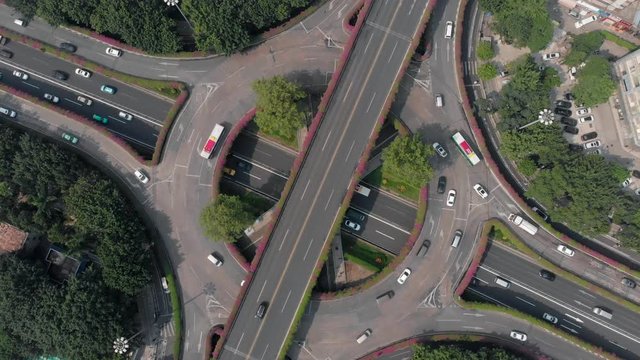 Top view of a multilevel traffic intersection. Simetria in the frame. The drone slowly rises, opening up more and more space. Heavy traffic